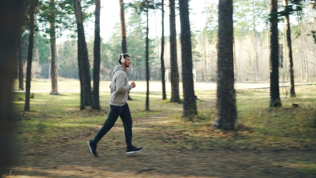 Person jogger med hodetelefoner på en skogssti