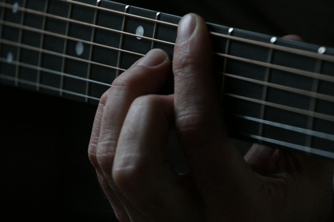 Nærbilde av en hånd som holder grep på gitarhalsen
